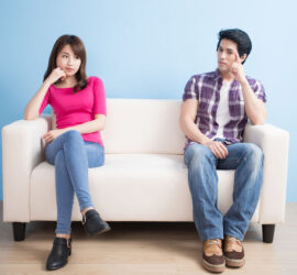 young couple feel bad and look somewhere sit on sofa at home